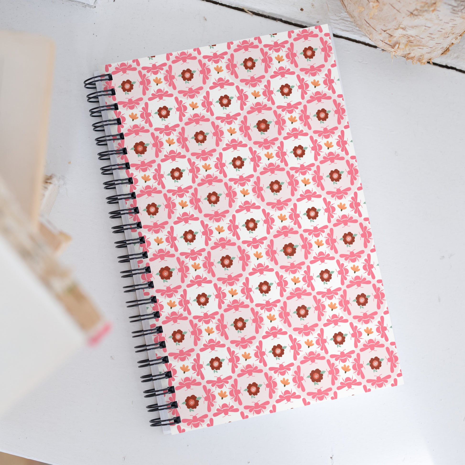 Notebook with a pink floral pattern on a white surface