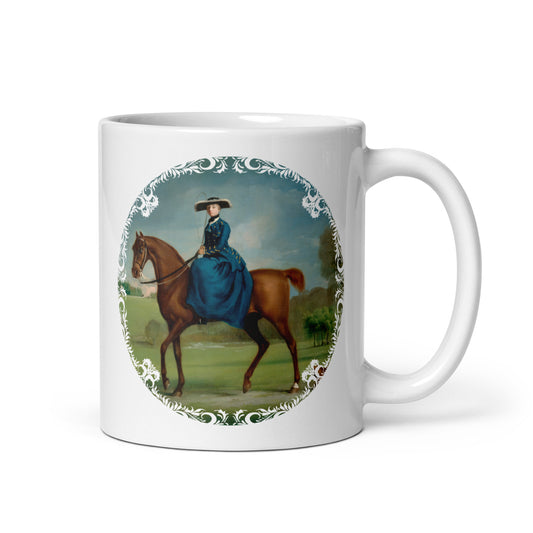 A white ceramic mug with an illustration of a woman in riding attire mounted on a horse, with a decorative border around the print.